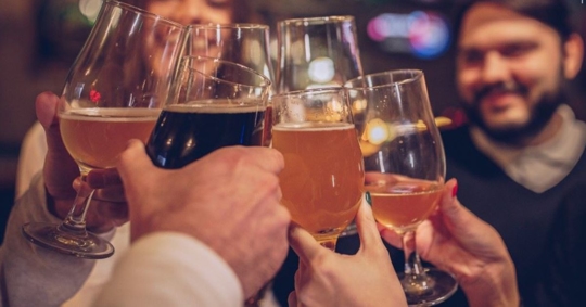 friends cheers with beers at a bar or pub
